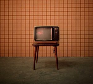 Vintage television set against a checked wallpaper background