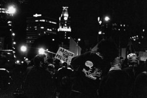 Protesters at night hold signs reading, "Abolish the Police"