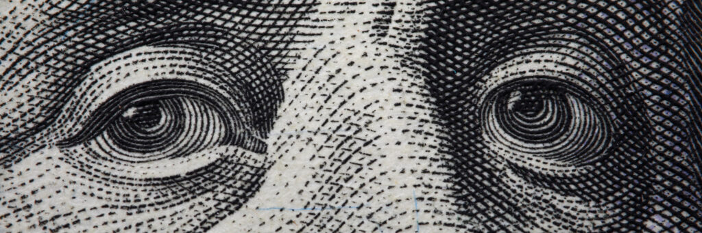 Close-up of Benjamin Franklin's face on hundred banknote.