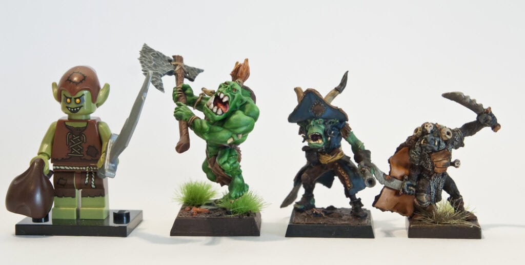 Ork Leaders from different systems, from left to right: Lego (For size comparison) Savage Orc Chieftain, Warhammer Fantasy/Age of Sigmar Captain Malo Gordab, Freebooters Fate Ork Chieftain, Armalion Photo Credit: Tobias Bomm via Flickr, https://www.flickr.com/photos/tobias_bomm/24309843632