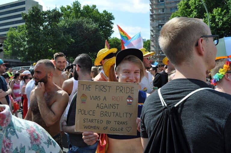 Christopher Street Day in Berlin (2018). Person holding a sign which says "The First Pride was a Riot against Police Brutality started by Trans Women of Color."